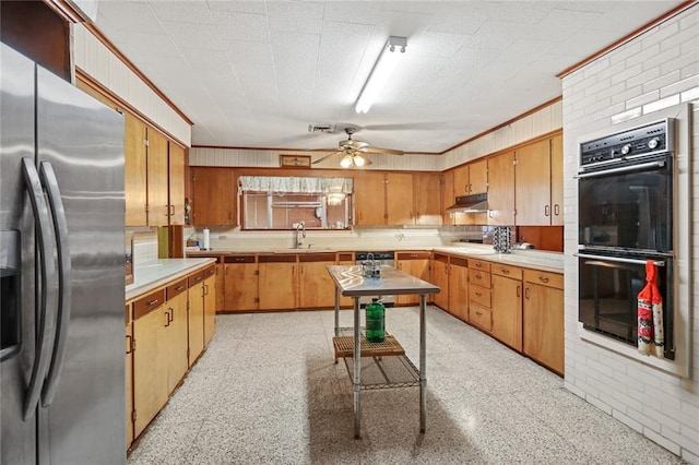 kitchen with sink, crown molding, black double oven, ceiling fan, and stainless steel refrigerator with ice dispenser