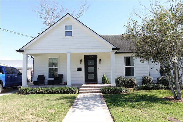 view of front of house with covered porch and a front lawn