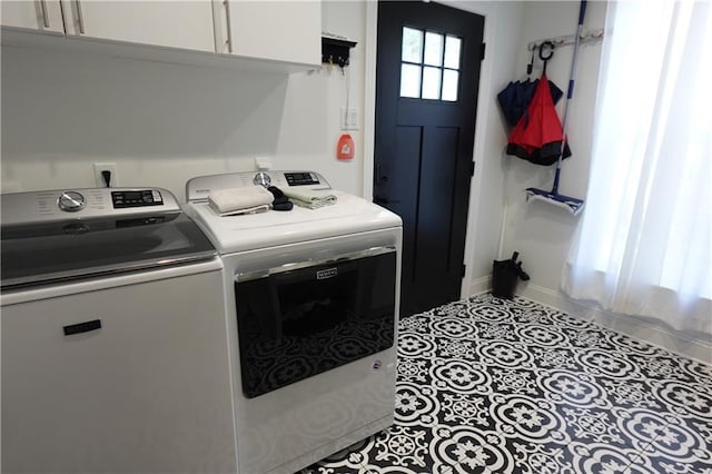 laundry area featuring cabinets, light tile patterned flooring, and washing machine and clothes dryer