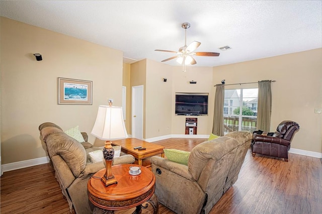 living room with dark wood-type flooring and ceiling fan