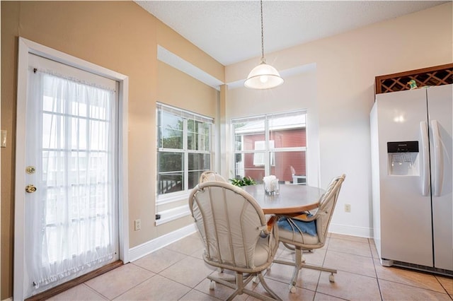 tiled dining room with a textured ceiling