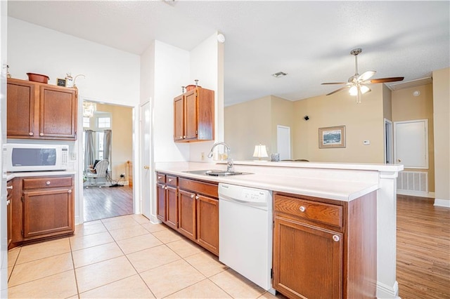 kitchen featuring kitchen peninsula, sink, white appliances, light hardwood / wood-style flooring, and ceiling fan with notable chandelier