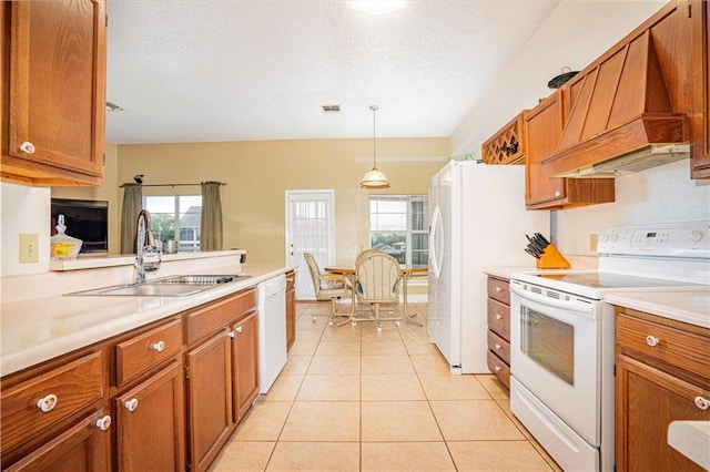 kitchen with sink, white appliances, light tile patterned floors, decorative light fixtures, and premium range hood