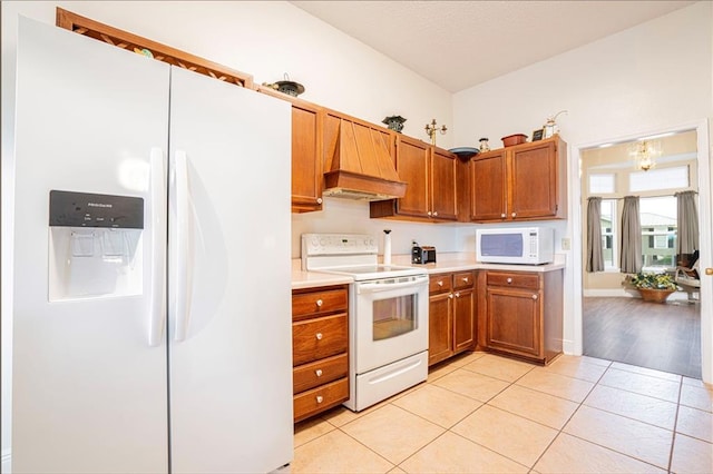 kitchen with custom exhaust hood, light tile patterned floors, and white appliances