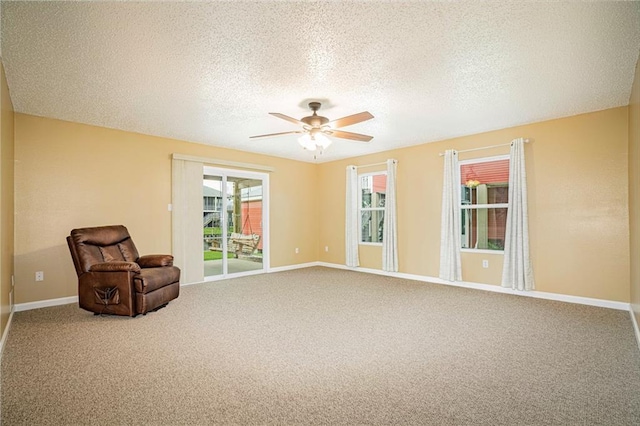 unfurnished room with carpet, ceiling fan, and a textured ceiling