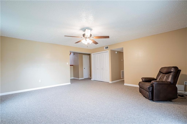 unfurnished room with ceiling fan, a textured ceiling, and carpet