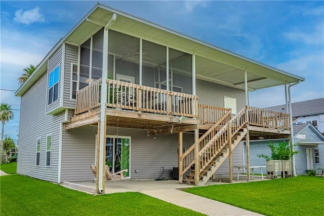 back of property featuring a lawn, a sunroom, and a patio area