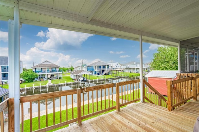 wooden deck with a lawn and a water view