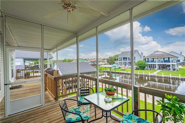 sunroom with a water view and ceiling fan