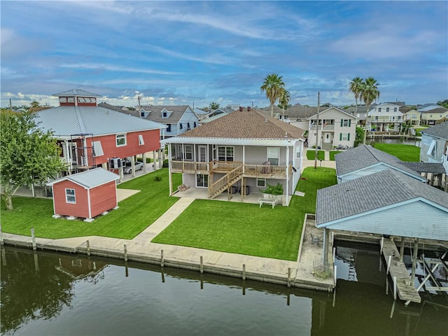 rear view of house with a yard, a water view, and a patio area