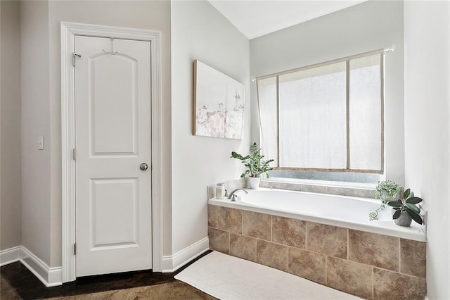 bathroom featuring a relaxing tiled tub