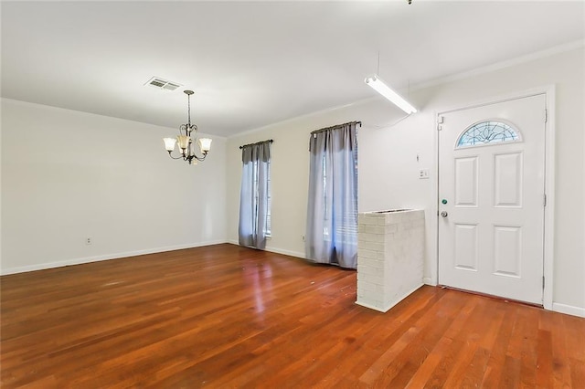 entryway with dark wood-type flooring and an inviting chandelier