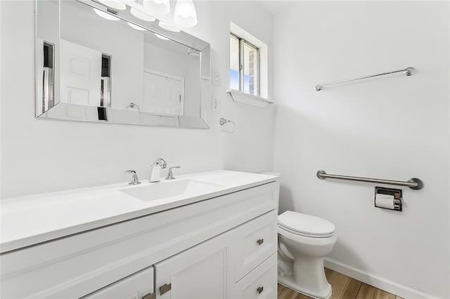 bathroom featuring hardwood / wood-style floors, vanity, and toilet