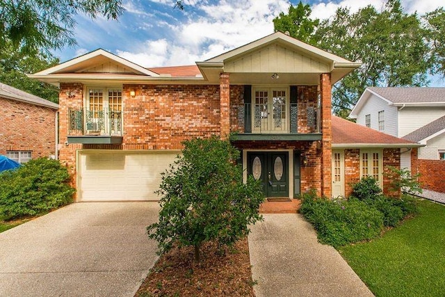 3412 Tolmas Dr, Metairie, LA 70002 - view of front of home with french doors, a balcony, concrete driveway, brick siding, and an attached garage