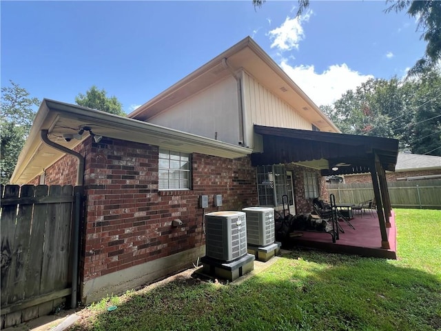 back of house with central AC and a lawn