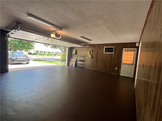 garage with a garage door opener and wooden walls