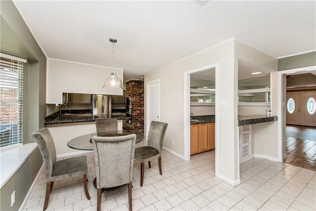 3412 Tolmas Dr, Metairie, LA 70002 - dining area featuring crown molding, a textured ceiling, light tile patterned flooring, and baseboards