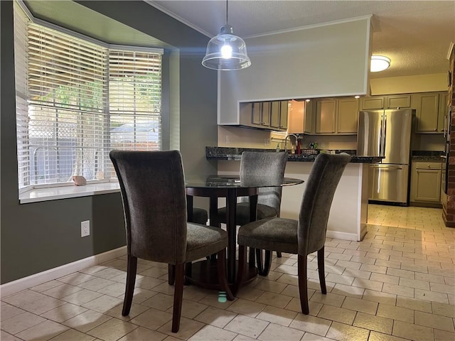 tiled dining space with sink and ornamental molding