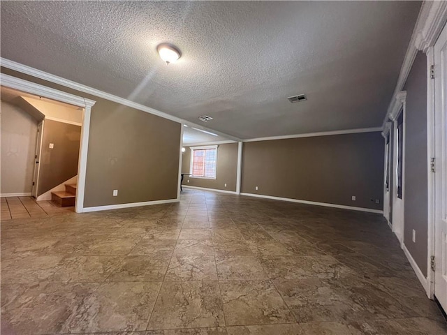 unfurnished room featuring ornamental molding and a textured ceiling