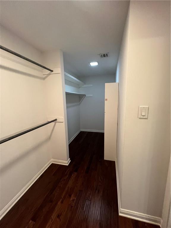 spacious closet featuring dark hardwood / wood-style floors