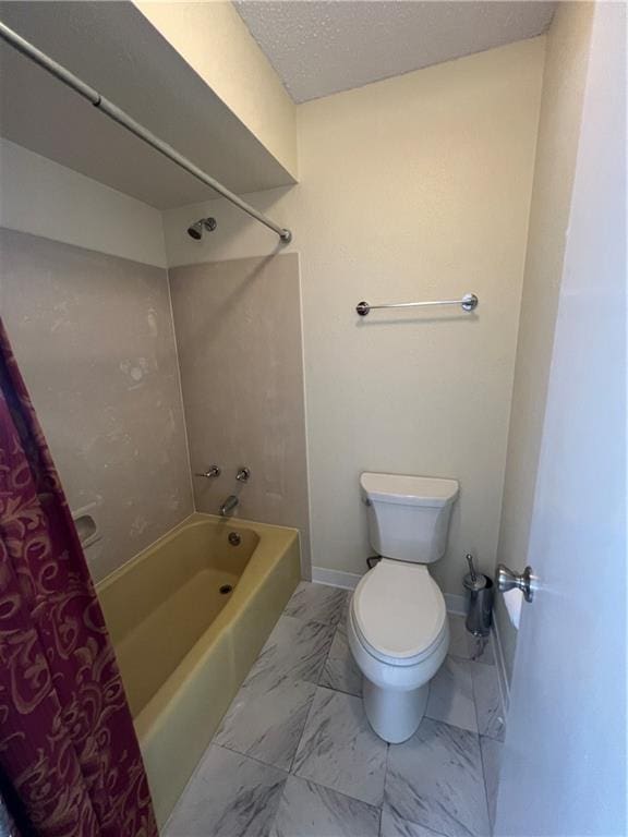 bathroom with tub / shower combination, a textured ceiling, and toilet