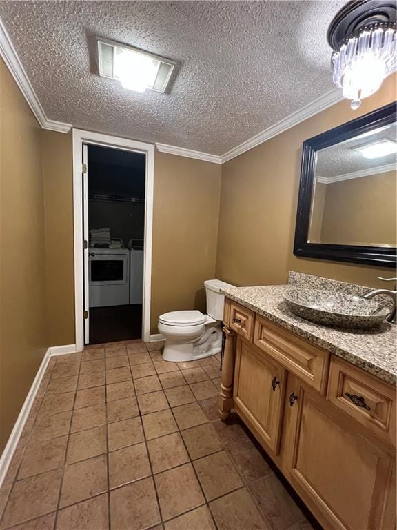 bathroom with washer and dryer, vanity, toilet, tile patterned floors, and a textured ceiling