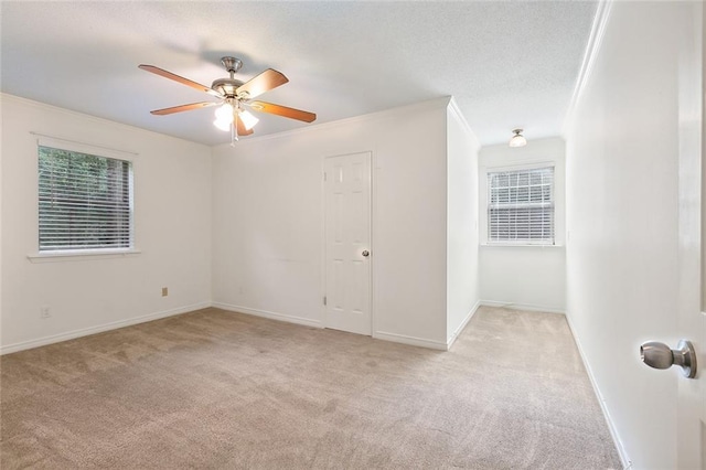 carpeted empty room with crown molding and ceiling fan