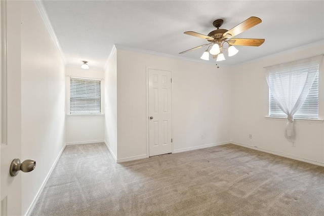 unfurnished room with crown molding, light colored carpet, and ceiling fan