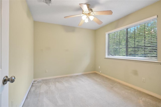 spare room with ceiling fan and light carpet