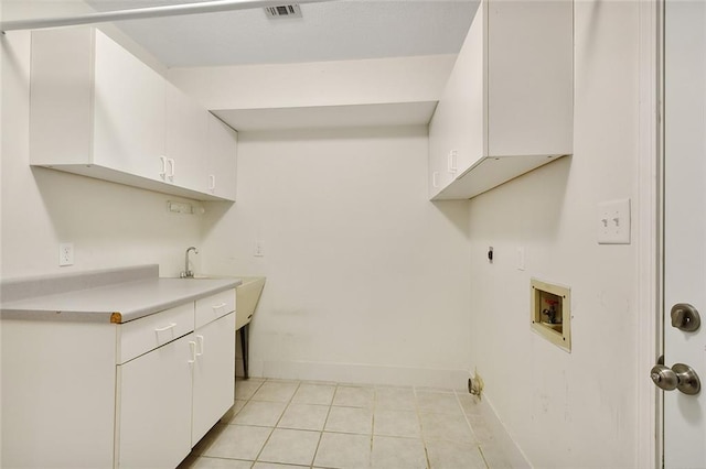 laundry room featuring cabinets, electric dryer hookup, washer hookup, and light tile patterned floors