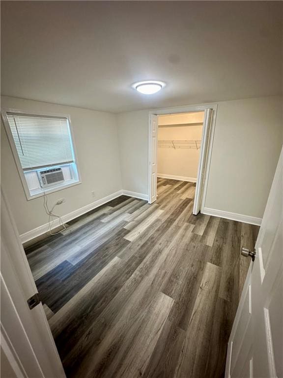 interior space with hardwood / wood-style flooring, cooling unit, a closet, and a spacious closet