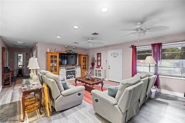 living room with light hardwood / wood-style flooring and ceiling fan