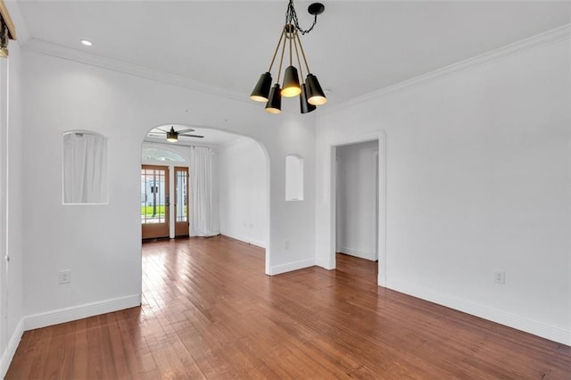 spare room with ceiling fan with notable chandelier, wood-type flooring, and ornamental molding