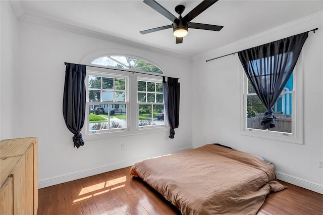 bedroom featuring ornamental molding, wood-type flooring, and ceiling fan