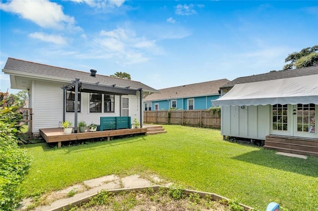 back of property with a pergola, a yard, and a deck