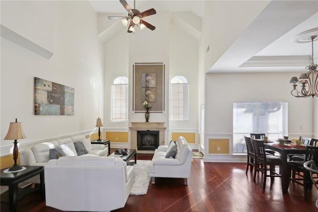 living room featuring a tray ceiling, high vaulted ceiling, ceiling fan, and dark hardwood / wood-style flooring