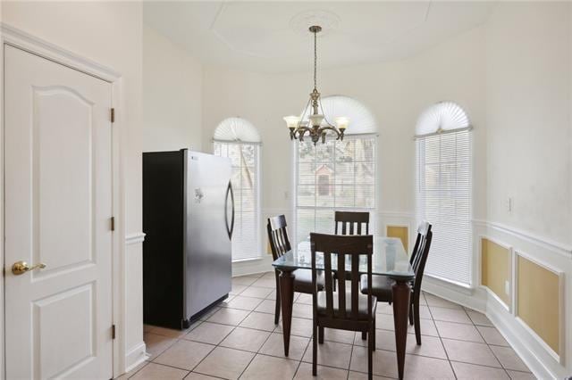 tiled dining area with a chandelier