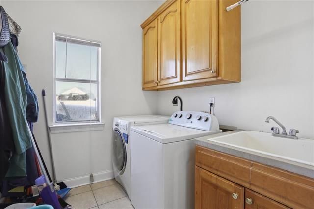 laundry room featuring cabinets, independent washer and dryer, sink, and light tile patterned floors