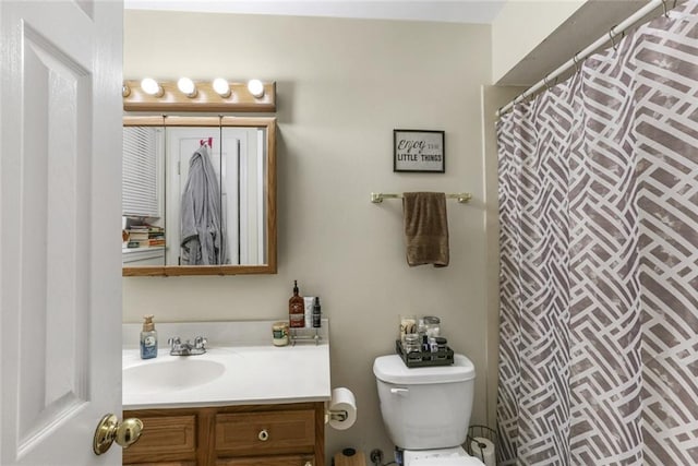 bathroom with vanity, curtained shower, and toilet