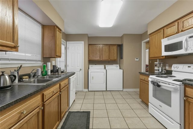 kitchen with white appliances, sink, washing machine and dryer, and light tile patterned floors