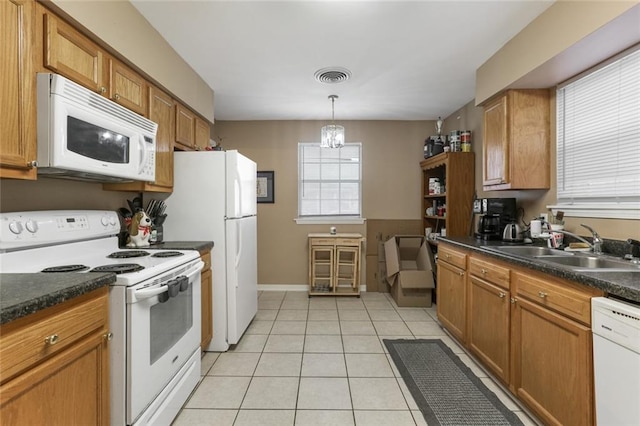 kitchen with pendant lighting, sink, white appliances, light tile patterned floors, and an inviting chandelier