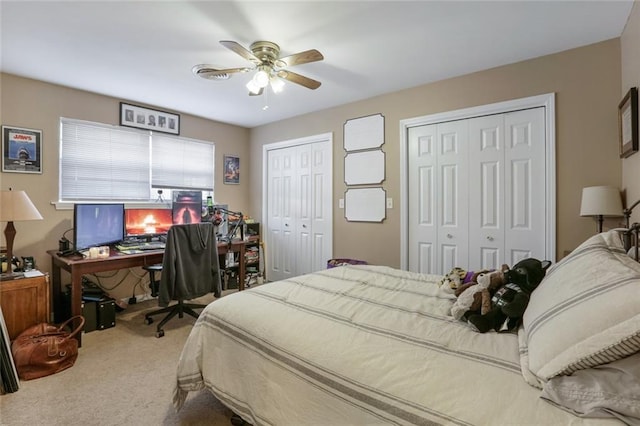 bedroom featuring carpet floors, two closets, and ceiling fan