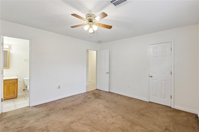 unfurnished bedroom with light carpet, connected bathroom, and ceiling fan