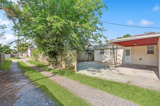 view of property exterior with a patio and a carport