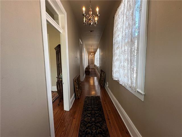 corridor featuring dark hardwood / wood-style flooring and a notable chandelier