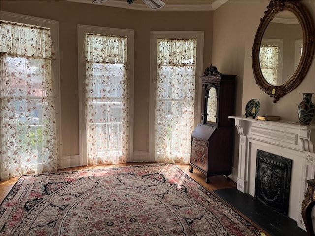 living room featuring hardwood / wood-style floors, ceiling fan, and ornamental molding