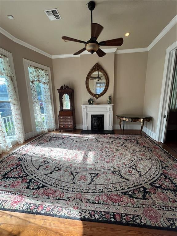 living room with crown molding, hardwood / wood-style floors, and ceiling fan