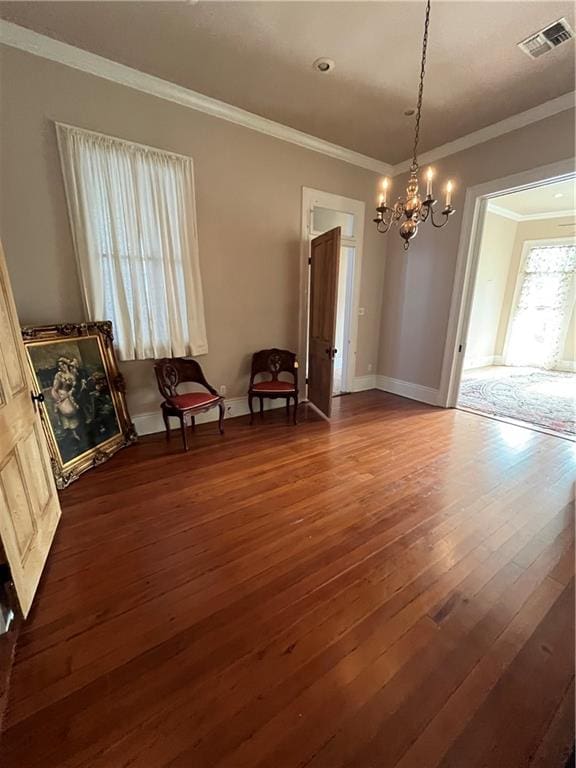 unfurnished dining area featuring a notable chandelier, crown molding, and dark wood-type flooring