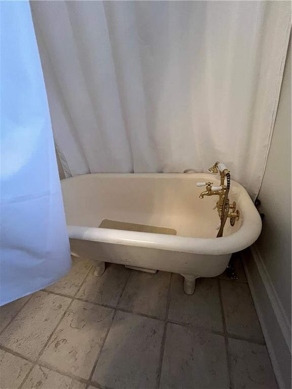 bathroom featuring tile patterned flooring and a tub