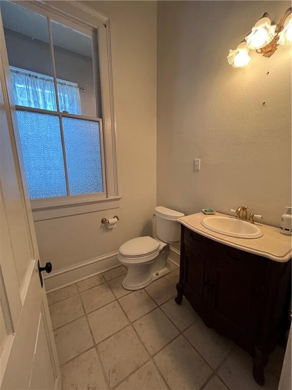 bathroom featuring tile patterned flooring, vanity, and toilet